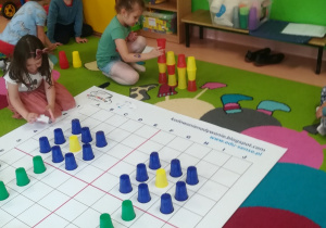 dzieci układają wieżę z kubków
